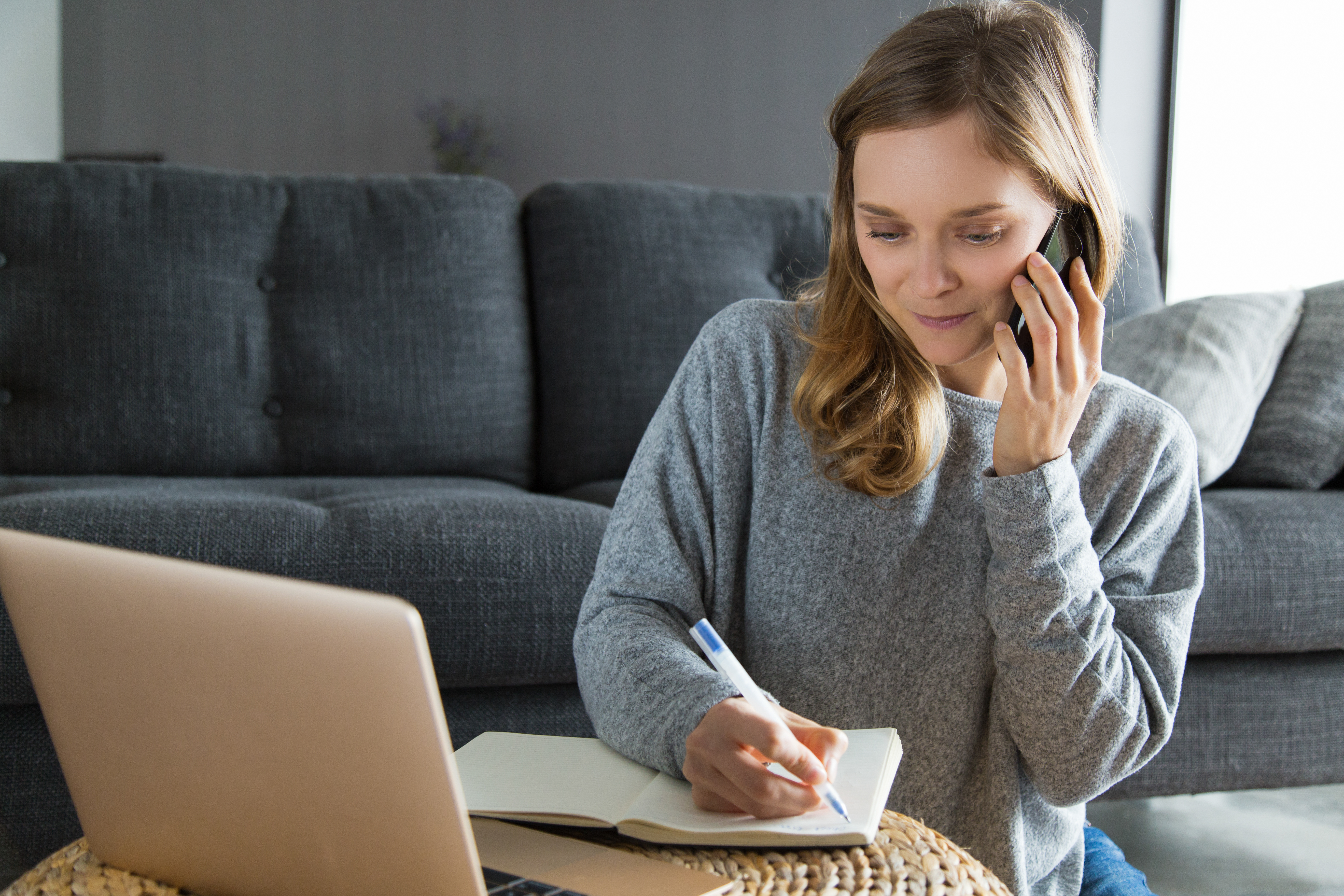 Woman speaking with a family intervention specialist and taking notes during a professional intervention consultation.