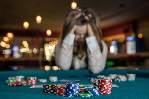 Woman showing frustration after gambling loss, representing gambling addiction