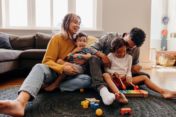 Family playing with their children, symbolizing stability and healthy connection with sober companion services.